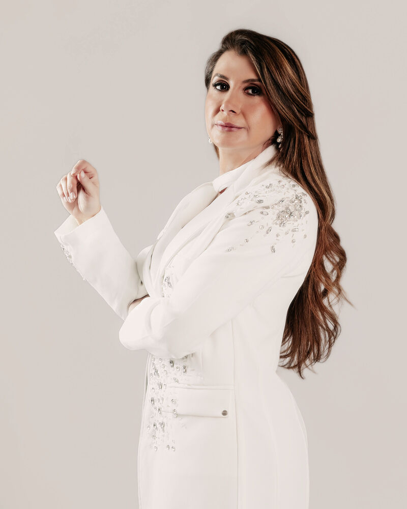 Dra. Etiene de Almeida, geriatra, em ambiente de estúdio com jaleco branco