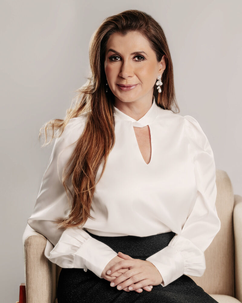 Dra. Etiene de Almeida sentada em poltrona, com expressão acolhedora